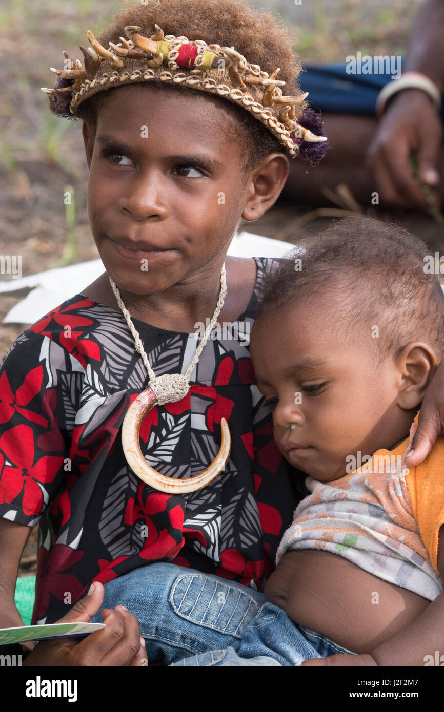 La melanesia, Papua Nuova guinea, fiume Sepik area, murik laghi, karau village. ragazza giovane con archetto di dente e collana e il bambino. Foto Stock