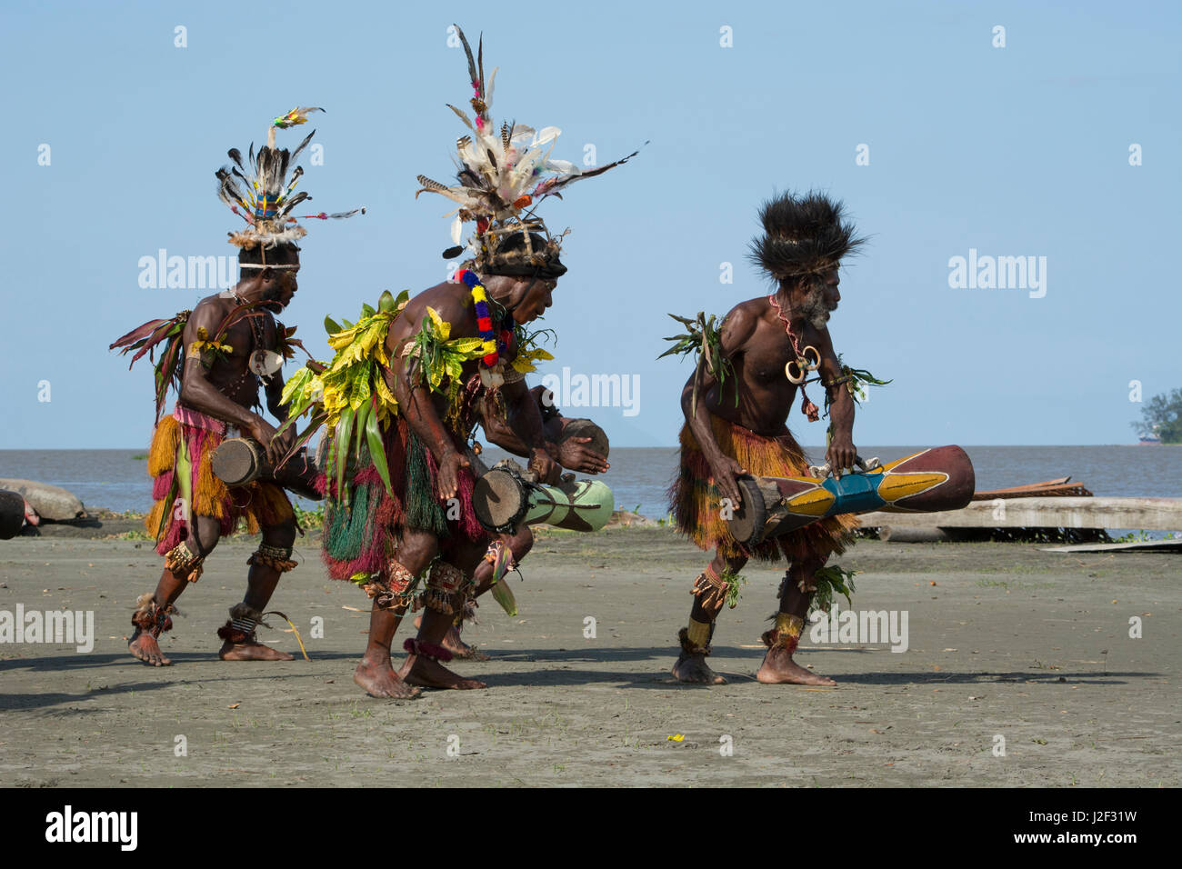 La Melanesia, Papua Nuova Guinea, fiume Sepik area, villaggio di Kopar. Tipico sing-sing benvenuti danza con gli uomini del villaggio nel tradizionale abito cerimoniale con fusti di legno. Foto Stock