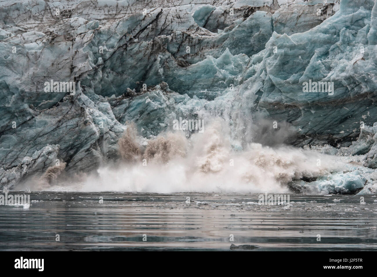 Con rumori assordanti un pezzo di ghiaccio si rompe da un ghiacciaio a Svalbard Foto Stock