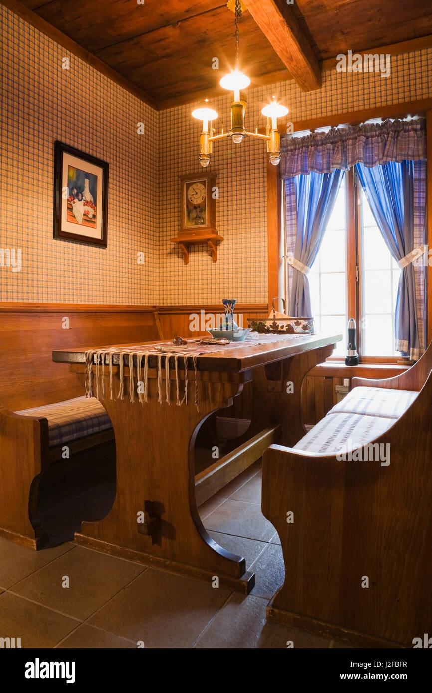 Tavolo per la colazione e seduta in legno panche in alcove accanto alla cucina all'interno di un 1976 ricostruito in stile cottage home registro Foto Stock