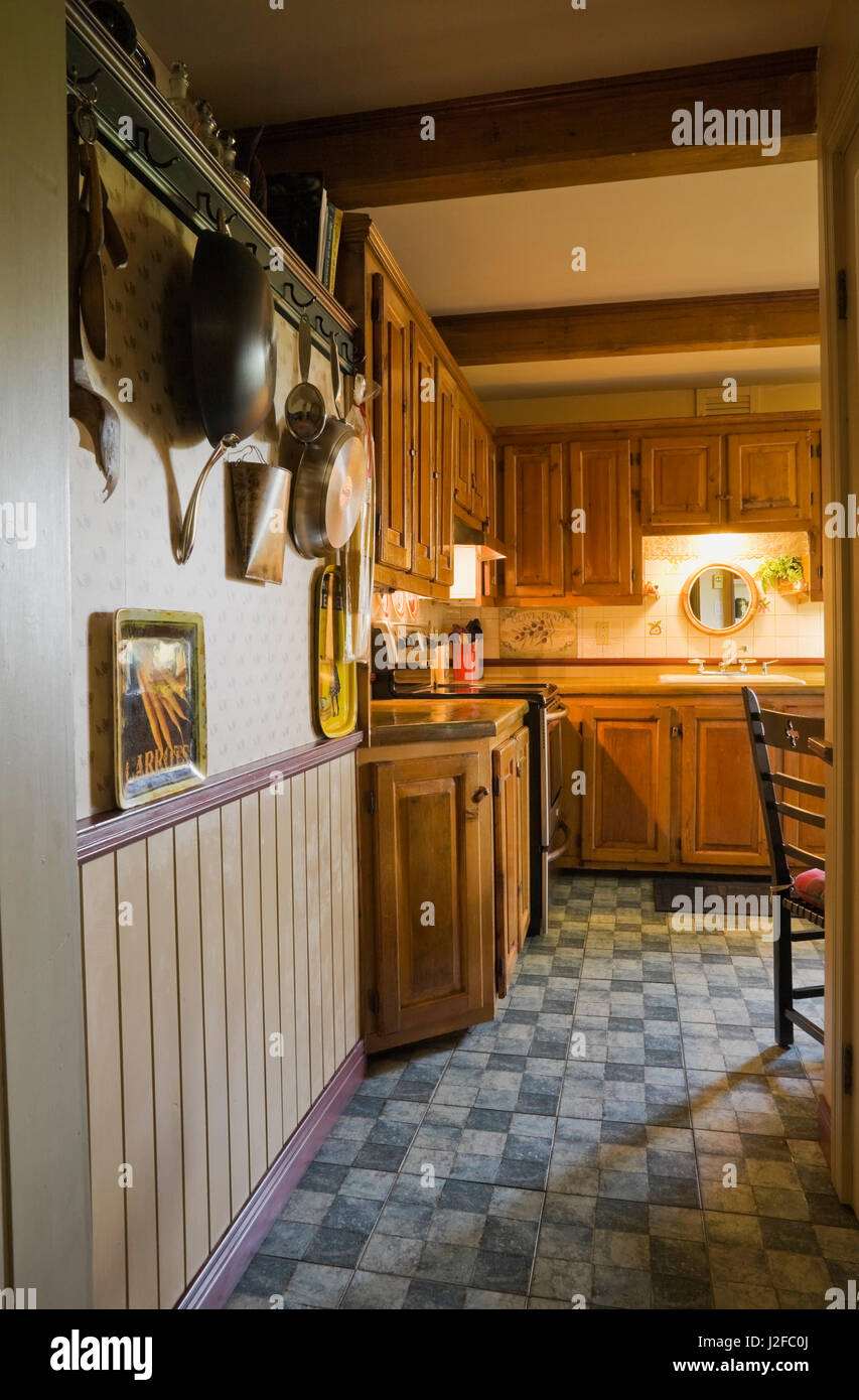 Corridoio che conduce alla cucina rustica con armadi in legno all'interno di un vecchio ricostruito 1850s cottage in stile casa di registro Foto Stock