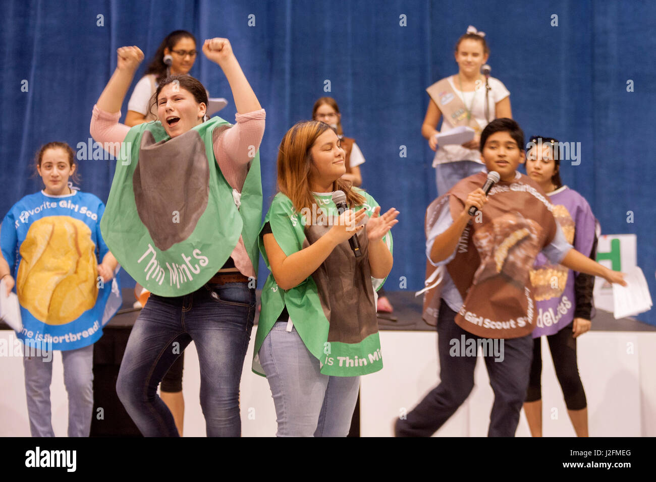 Vestito in Girl Scout cookie costumi, multirazziale di membri di un Irvine, CA, high school dance club intrattenere un pubblico di scout in apertura del cookie stagione di vendita. Foto Stock