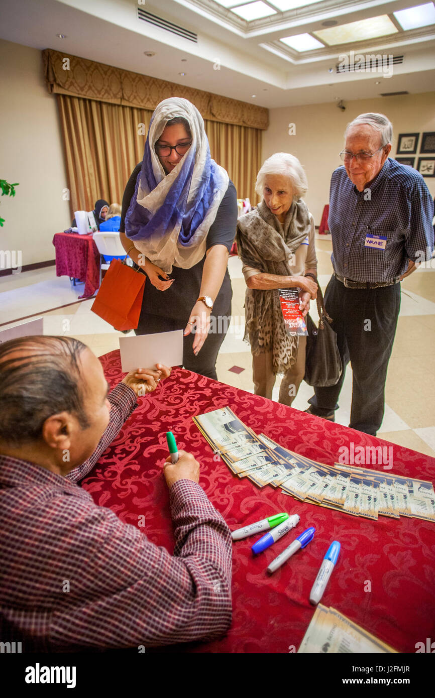 Una coppia senior visitando un Anahem, CA, Moschea di vedere i loro nomi scritti in arabo. Nota il visitatore a sinistra con un hijab o la tradizione islamica testa femmina sciarpa. Foto Stock