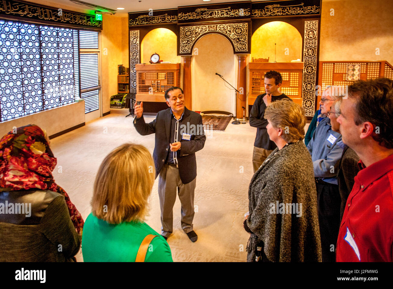 Una guida mostra non-musulmani i membri della comunità locale attraverso una moschea sui visitatori al giorno in Mission Viejo, CA. Nota arabo scrivere sul muro islamico e la decorazione di interni. Foto Stock