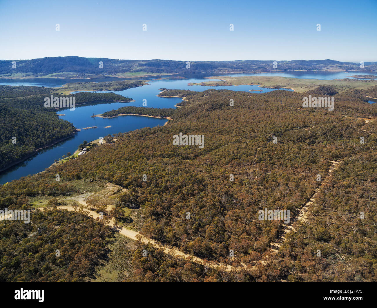 Vista aerea del Lago Jindabyne e nevoso fiume sulla luminosa giornata di sole. NSW, Australia Foto Stock