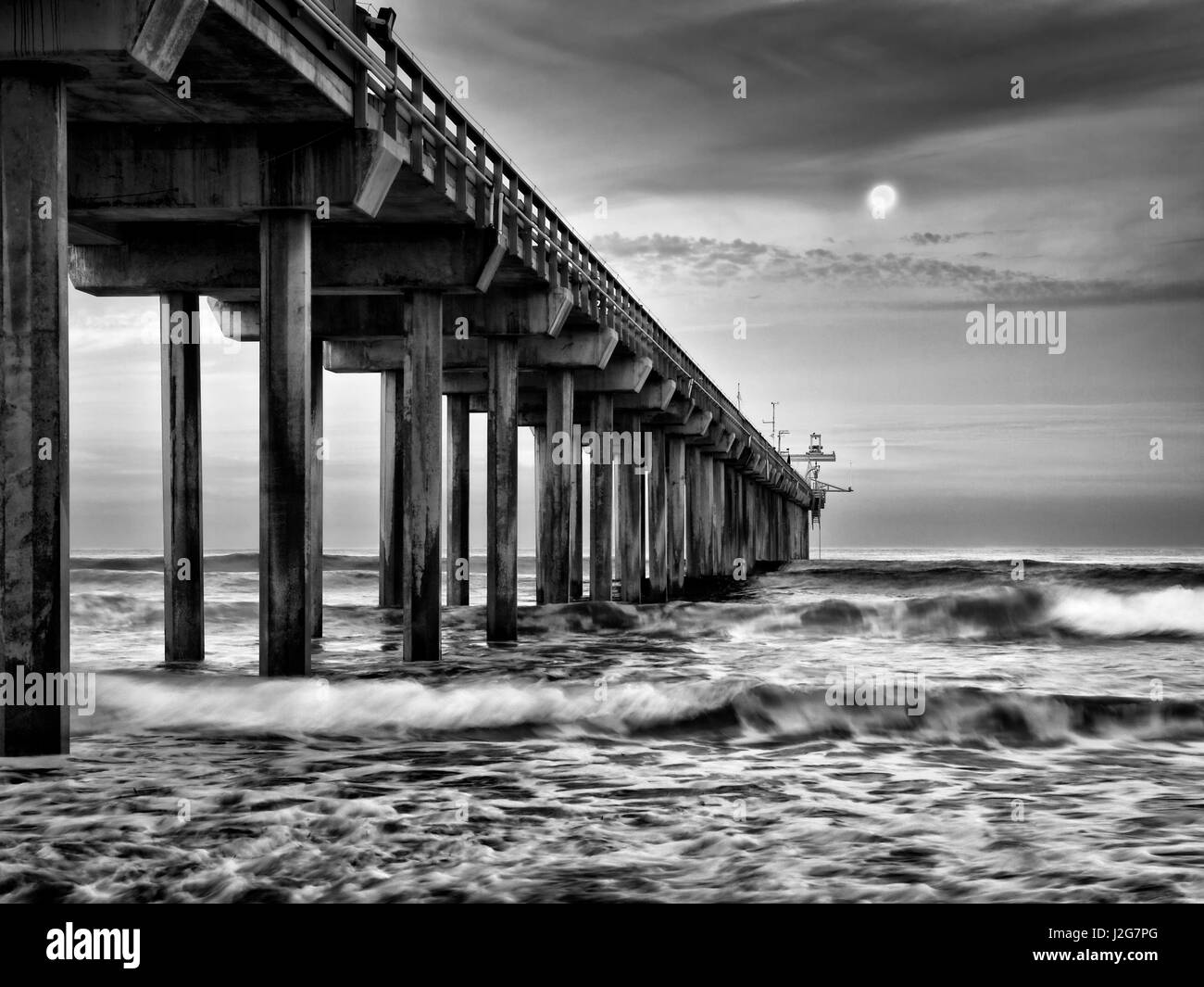 Stati Uniti, California, La Jolla, luna piena impostazione all'alba su Scripps Pier, La Jolla Shores Foto Stock