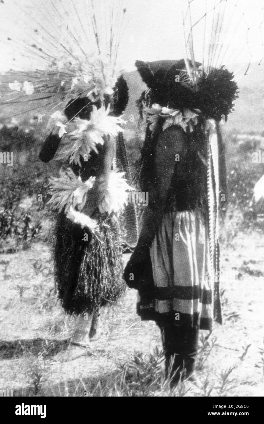 Storica fotografia in bianco e nero di due Pomo danzatori vestiti di danza tradizionale di regalia durante una grande testa cerimoniale di danza, California Foto Stock