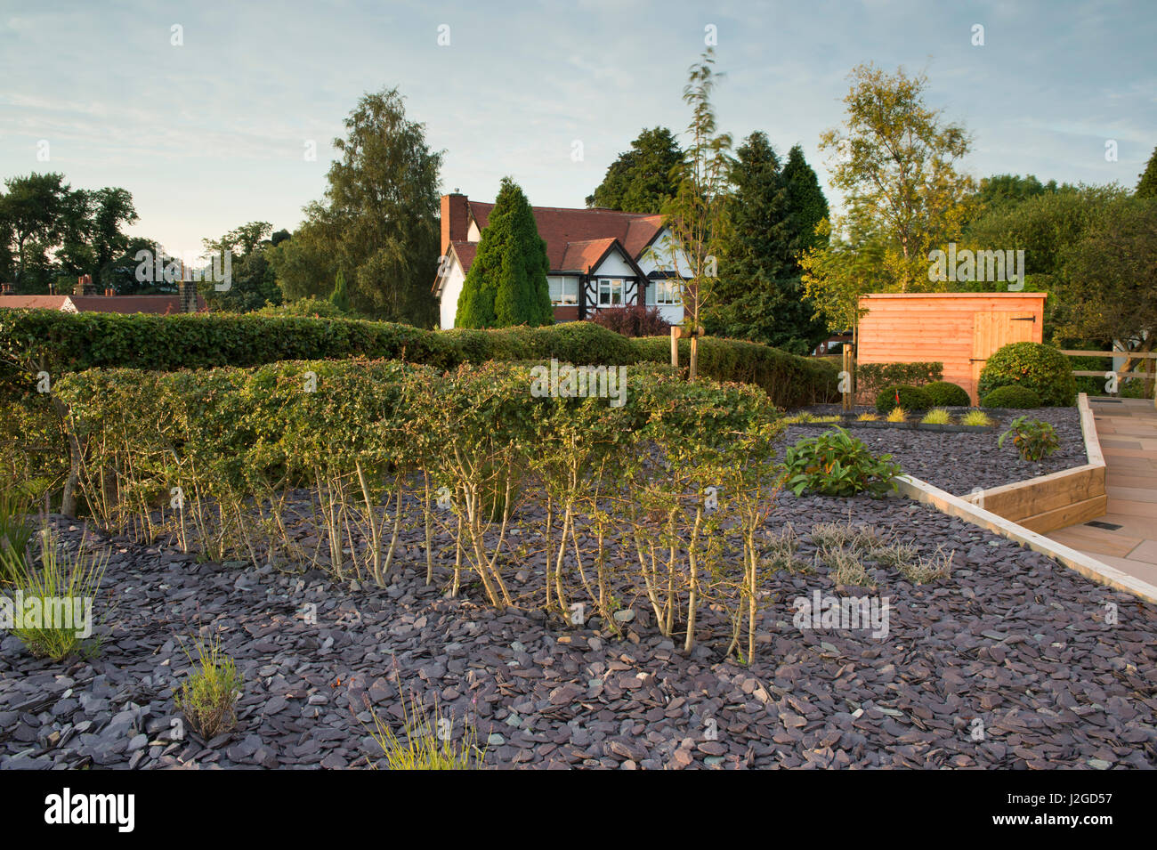 Bellissimo giardino privato, nello Yorkshire, Inghilterra, Regno Unito - design elegante e contemporaneo, paesaggio duro (pavimentazioni) capannone & nuovi impianti in legno letti sollevata. Foto Stock