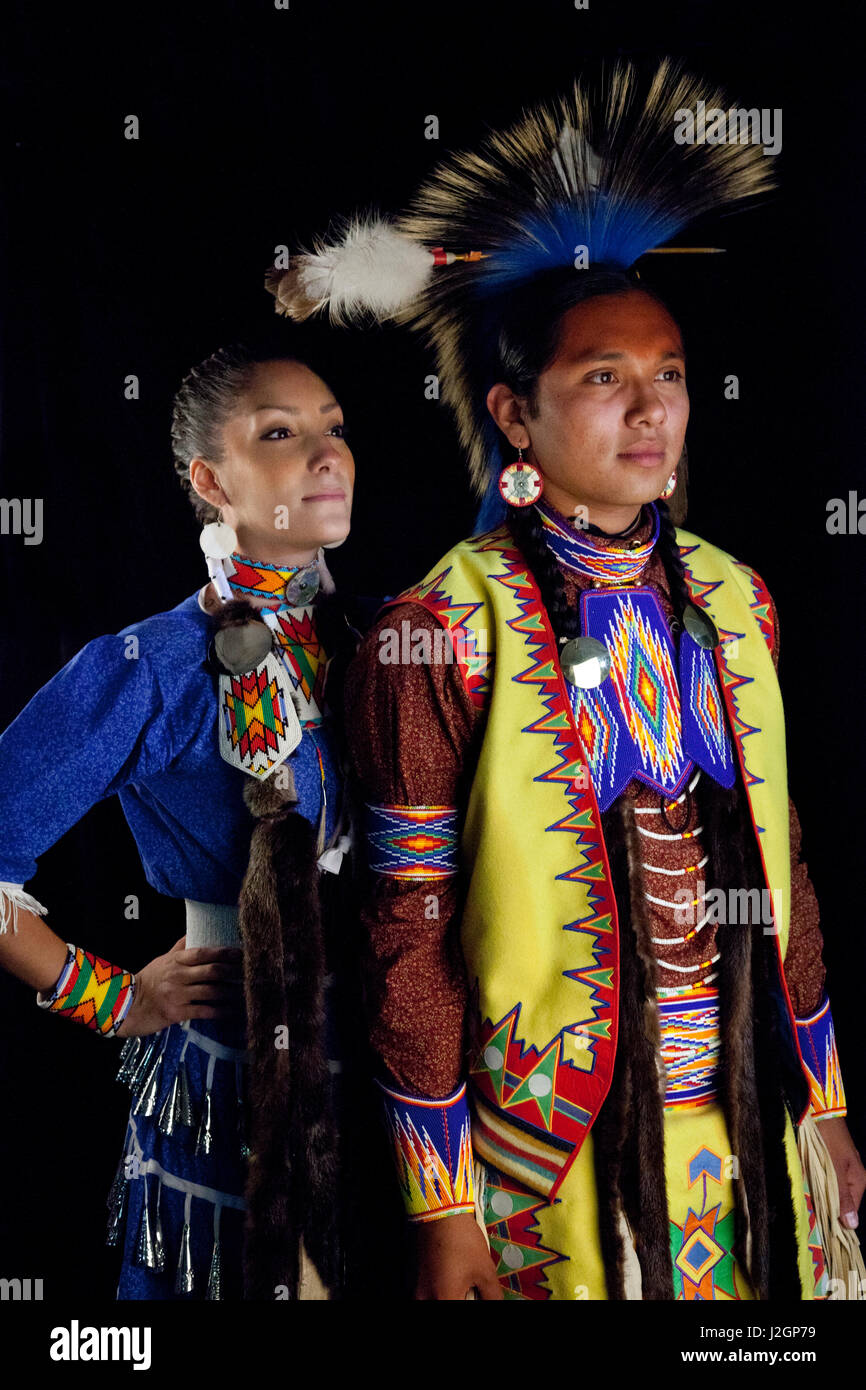 Giovane adolescente di ragazzo e ragazza vestita in un tradizionale Pow Wow dance regalia pongono accanto a uno sfondo nero. Challis Baldwin (Shoshone Bannock) e Ian Stevens Foto Stock