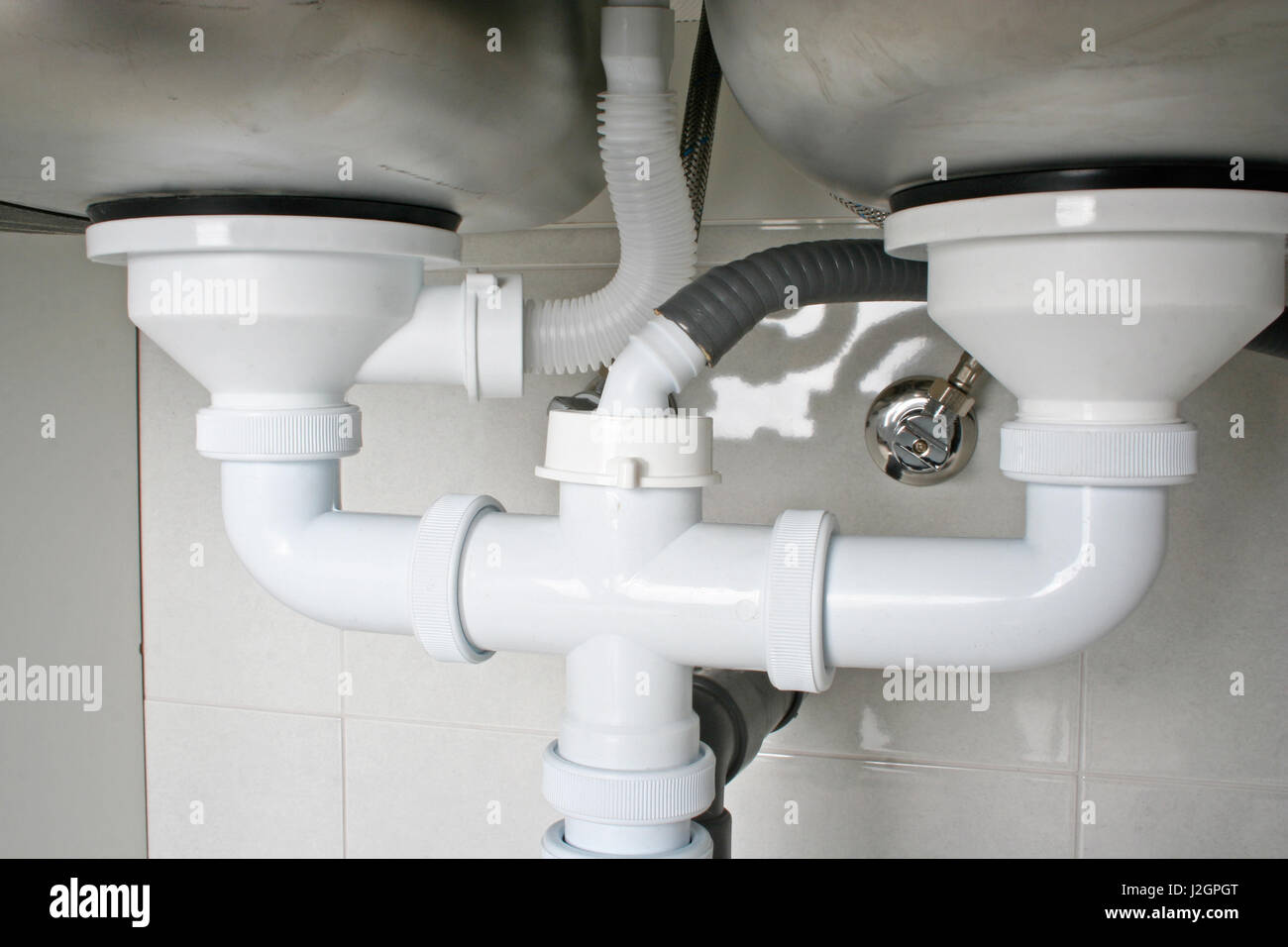 I tubi di scarico al di sotto del lavello di una cucina con lavastoviglie  collegamento Foto stock - Alamy