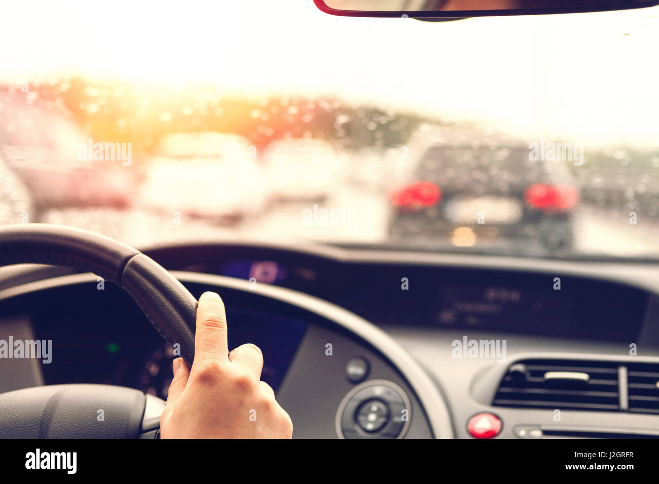 Alla guida di una vettura in condizioni di cattivo tempo nel traffico - sfondo sfocato Foto Stock