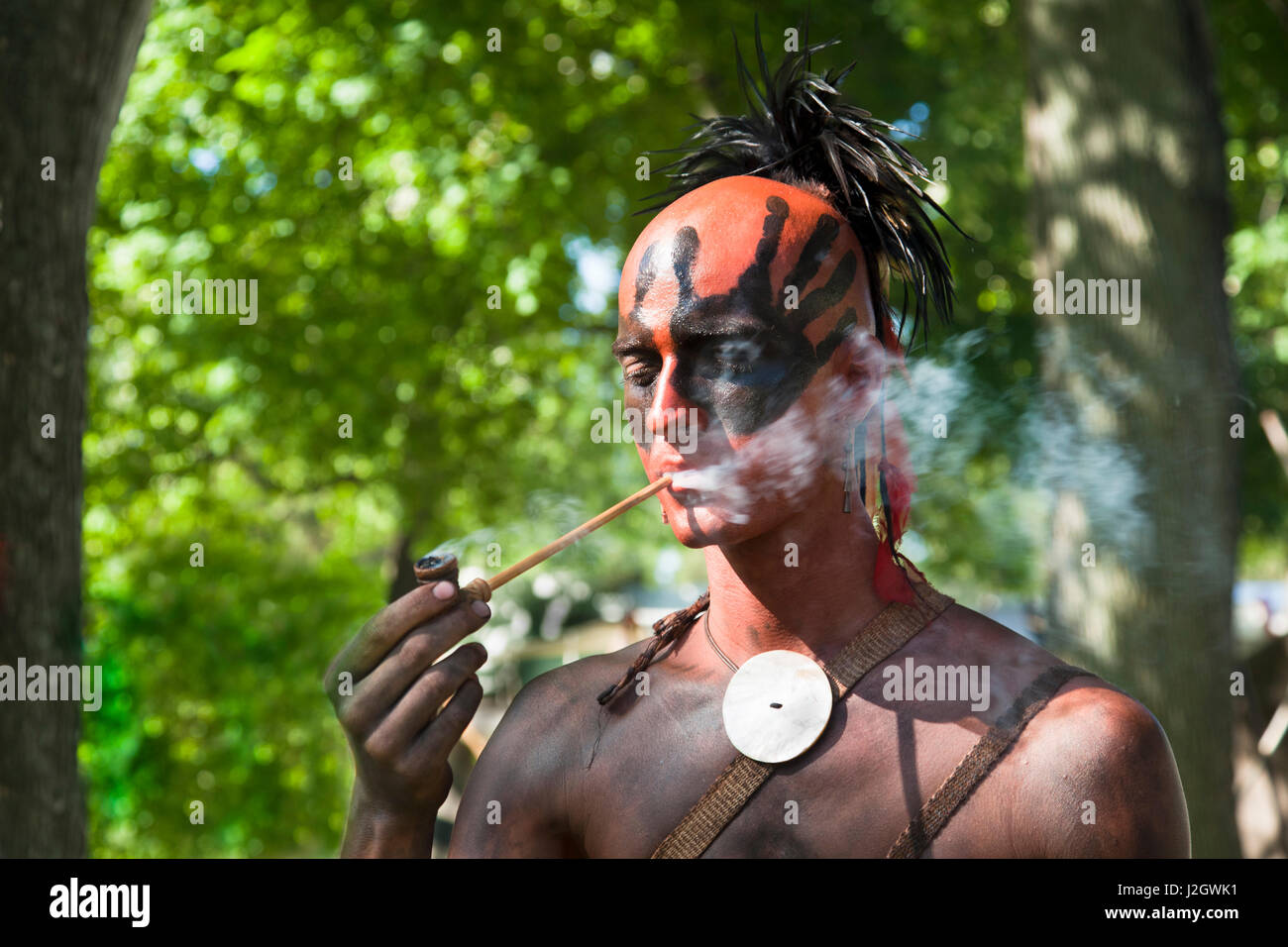 Close-up di un nativo americano della tribù del Nordest fuma una tubazione durante il Fort Niagara francese Guerre indiane rievocazione storica, NY Foto Stock