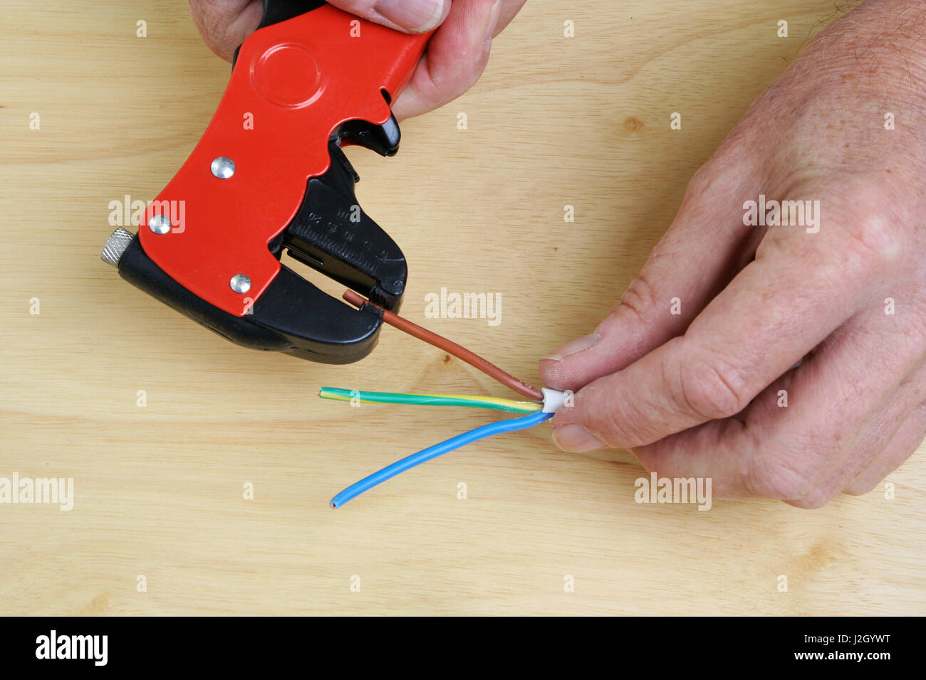 Spelatura dei fili elettrici con un attrezzo speciale Foto Stock