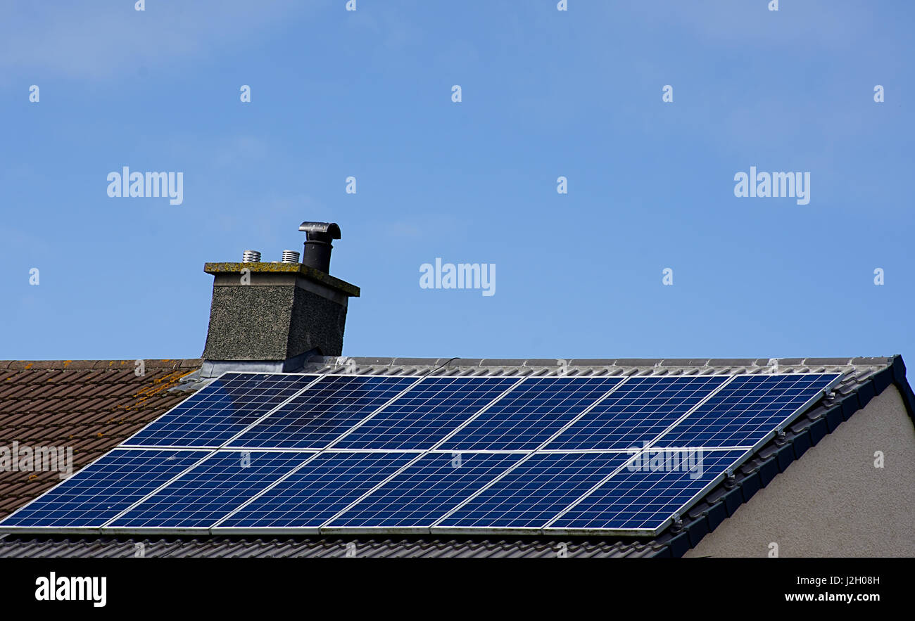 Pannelli solari inclinate sul tetto della casa con cielo blu sullo sfondo,il Galles del Nord,UK.Energy Uk,fonte di energia rinnovabile.Pannello solare il buon tempo,cielo chiaro,Uk. Foto Stock