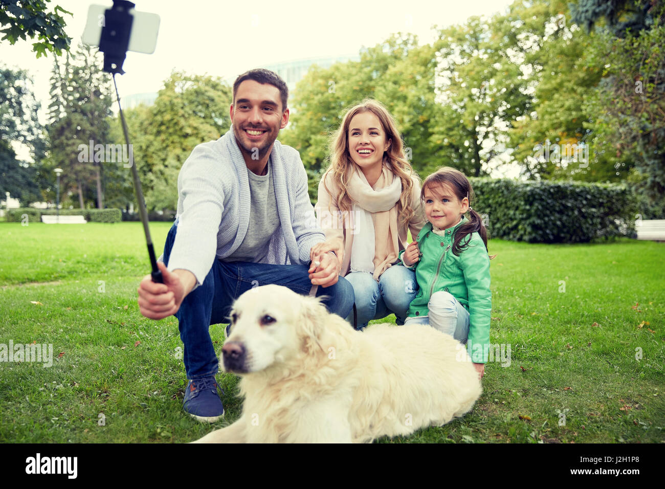 La famiglia felice con il cane tenendo selfie tramite smartphone Foto Stock