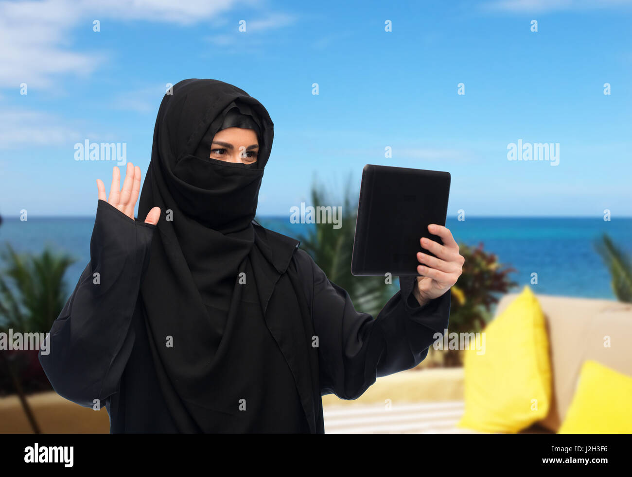 Donna musulmana in hijab con tablet pc aventi chat Foto Stock