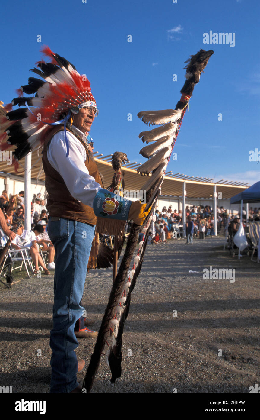 Onorevole Blackfeet anziano nel pieno eagle copricapo e guanti bordati detiene un aquila personale durante il Grand Entry all'annuale Indian Days Festival a Browning Montana Foto Stock