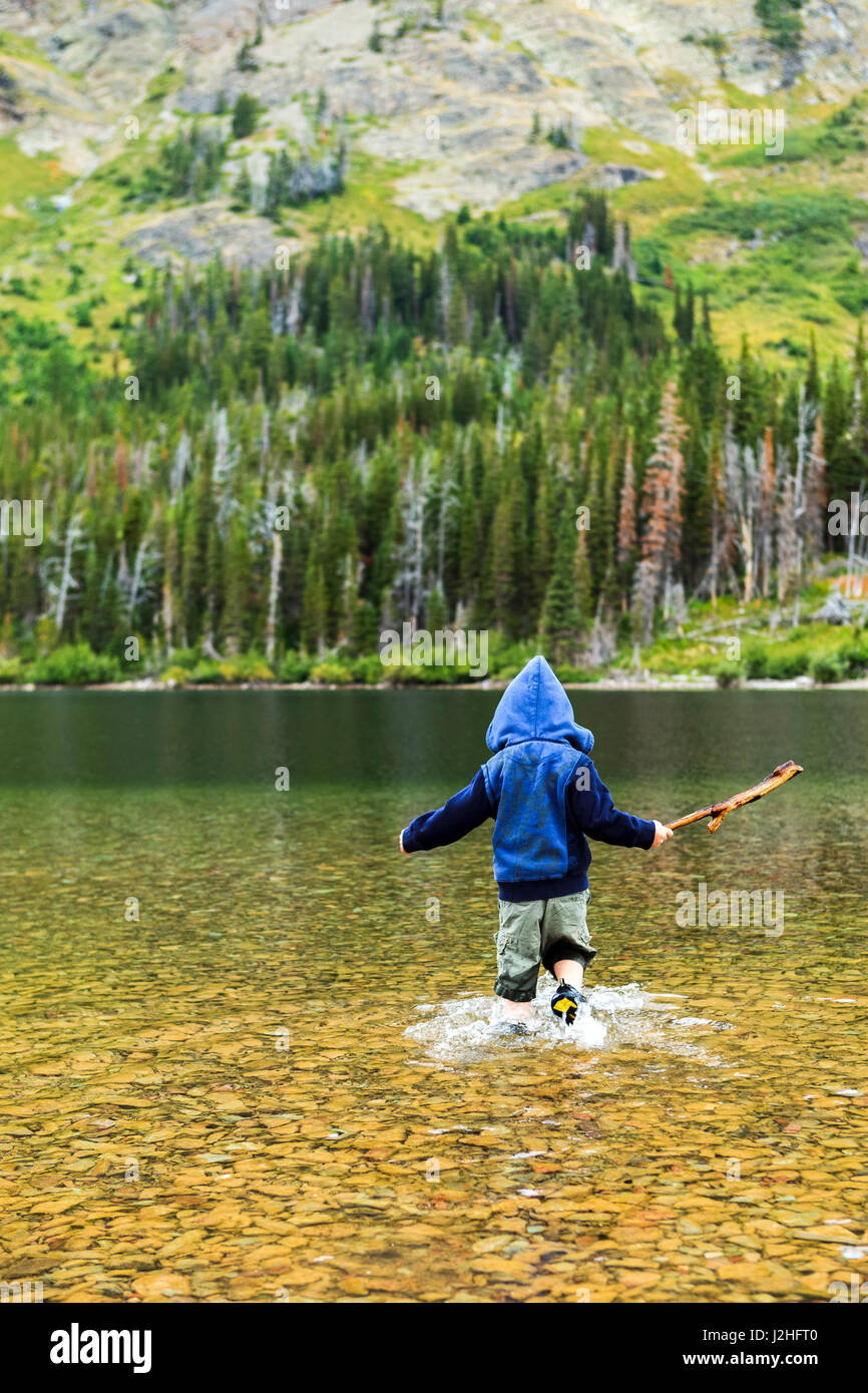 Kid giocando nel lago glaciale, Montana, USA Foto Stock