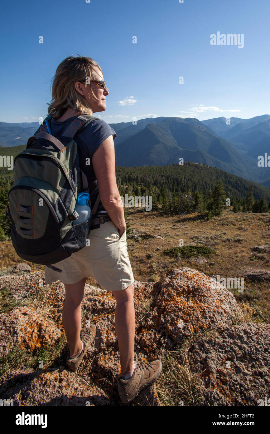 Donna guarda all'orizzonte durante le escursioni in montagna al di fuori di Big Sky, Montana Foto Stock