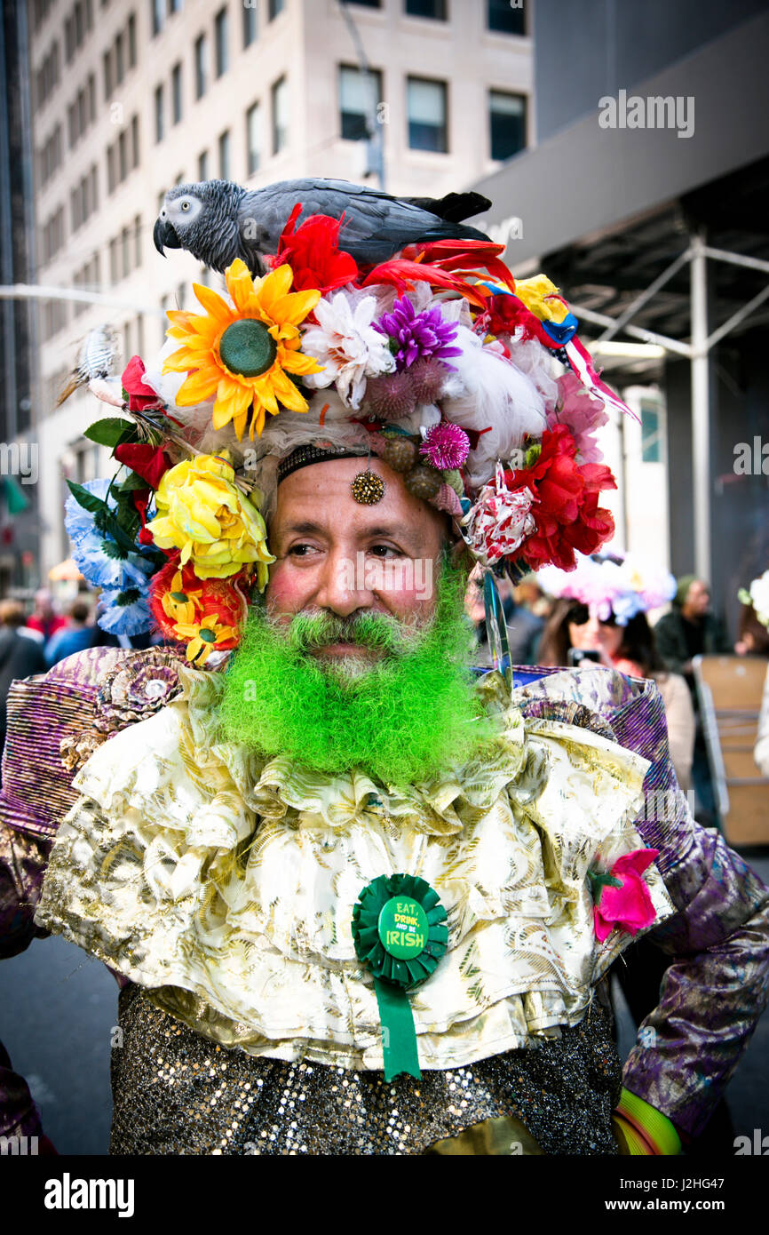 New York City, NY, STATI UNITI D'AMERICA. Pappagallo grigio africano sulla parte superiore di un abito garishly uomo al Easter Parade all 5th Ave. Foto Stock