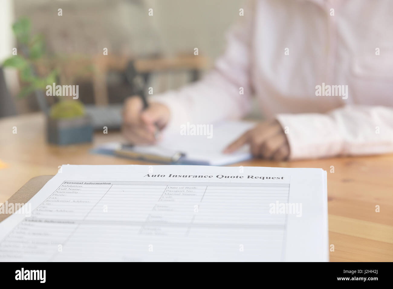 Persona 's mano compilare assicurazione auto modulo su una clipboard - Motore auto rimborso concetto del veicolo Foto Stock