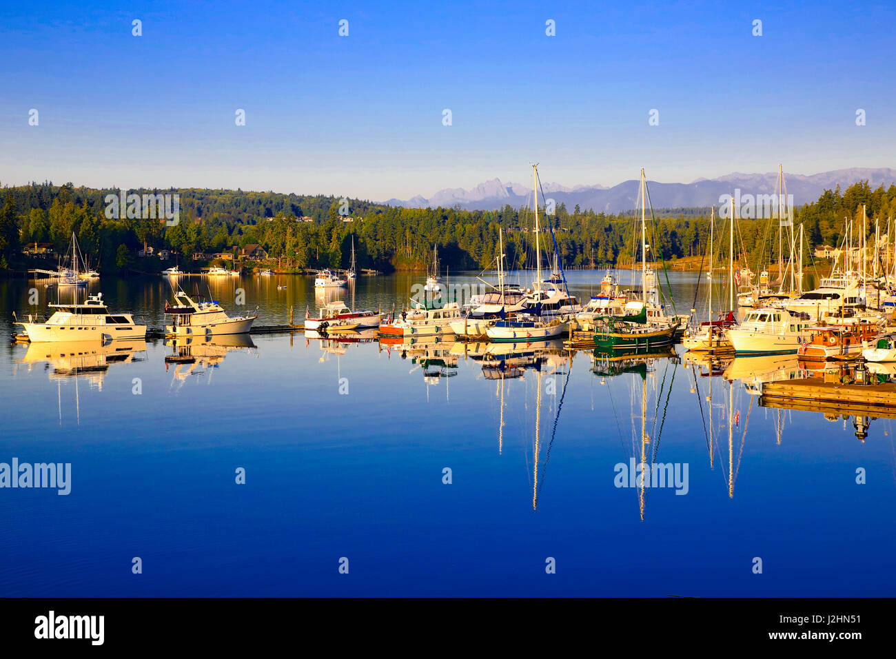 Port Ludlow Marina, Porto Ludlow, nello Stato di Washington. Barche su un porticciolo con le Montagne Olimpiche Foto Stock