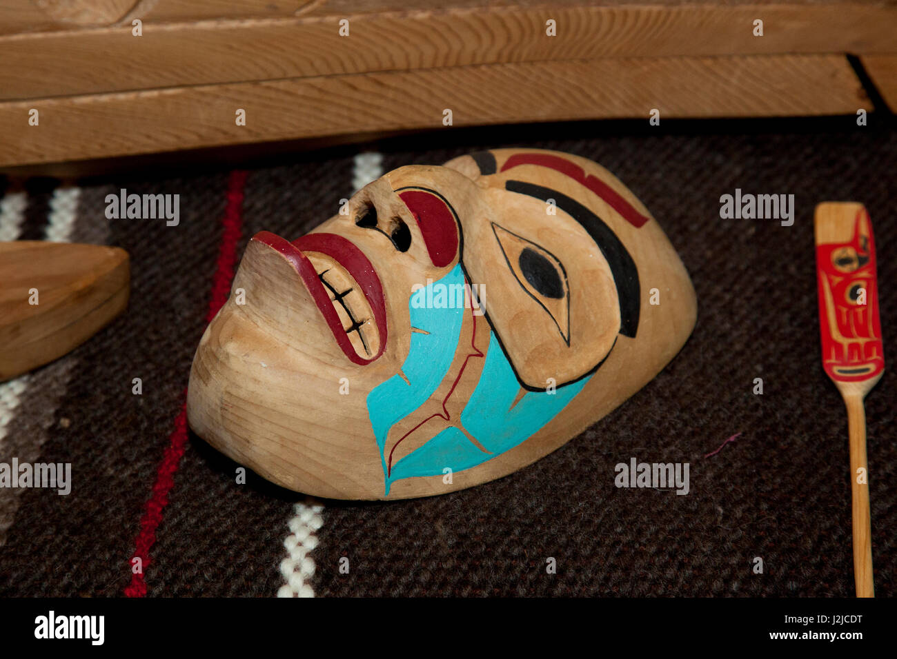 Scolpita in legno di cedro cerimoniale maschera umana visualizzata sulla coperta di lana all'interno del longhouse situato all'Hilbub Centro Culturale e Museo situato sulla Tulalip tribù Prenotazione in Marysville, WA Foto Stock