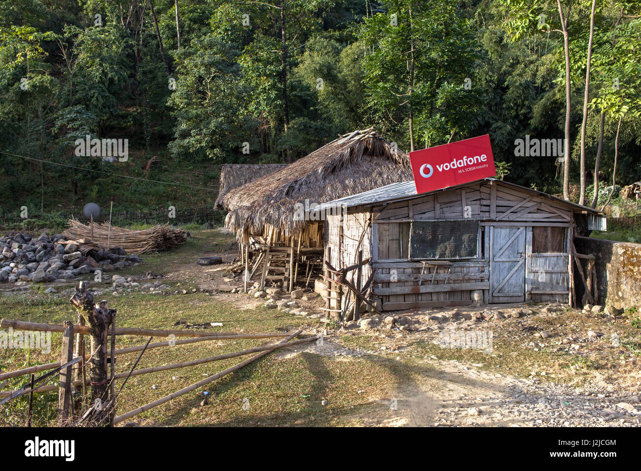 Staccato di sgangherate hut decorata con un grosso tabellone sul tetto con un annuncio pubblicitario del "Vodafone" Foto Stock