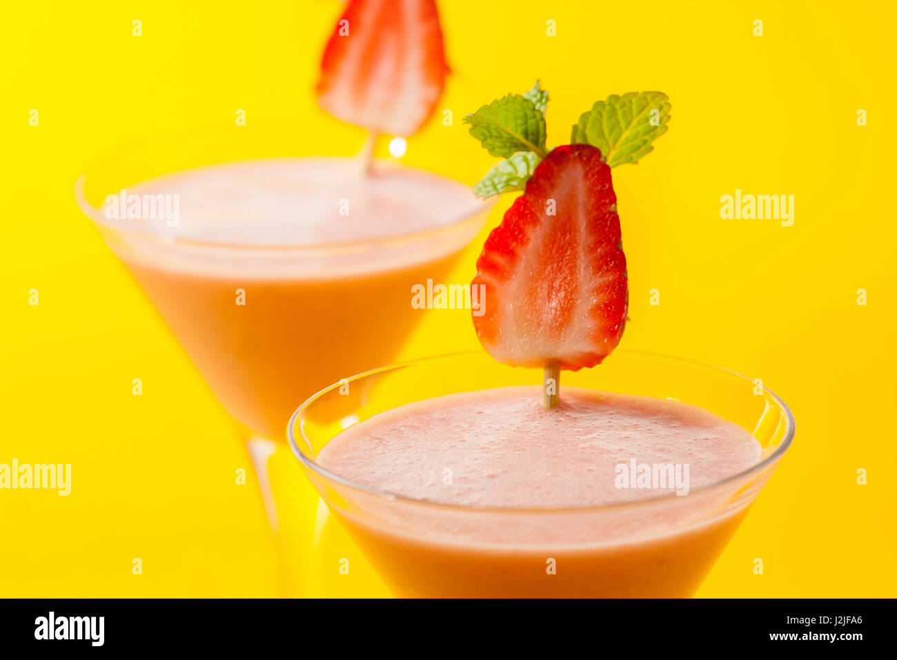 Bella frullati di fragole su sfondo giallo. Foto Stock