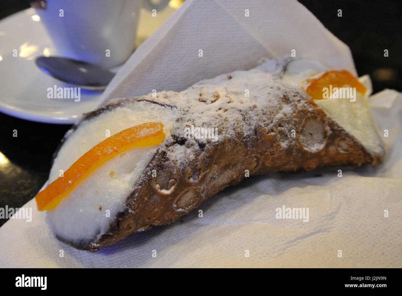 Un tipico cannolo siciliano su un tovagliolo bianco Foto Stock