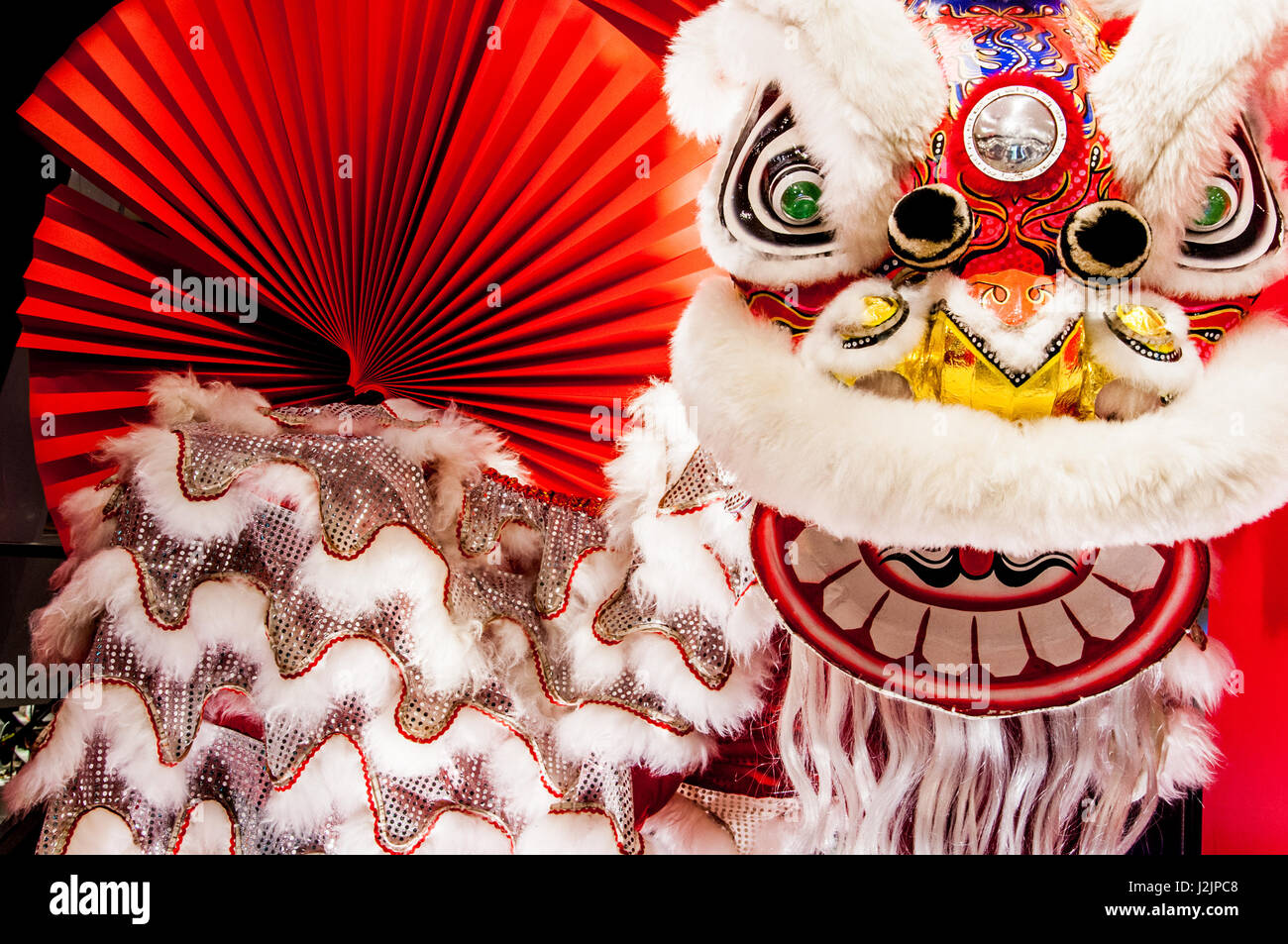 Tradizionale Cinese colorati anno nuovo Lion con ventaglio rosso come sfondo Foto Stock