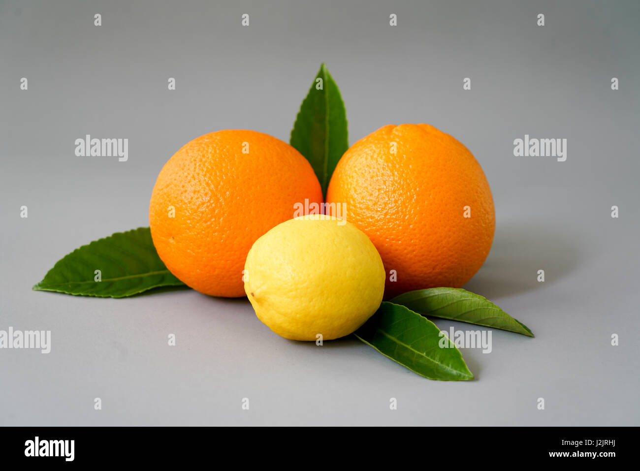 Organici di arancia e di limone su sfondo grigio - isolato Foto Stock