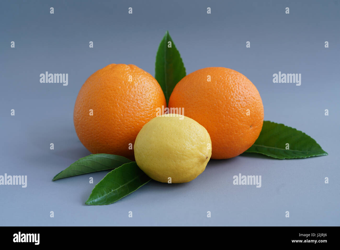 Organici di arancia e di limone su sfondo grigio - isolato Foto Stock