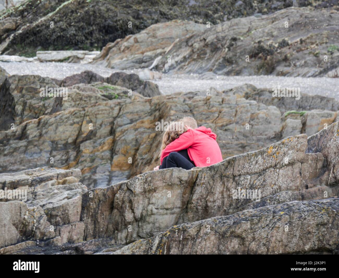 Ilfracombe, Devon, Regno Unito. Il 29 aprile 2017. Coppia giovane sulla spiaggia in una fredda giornata a sopraggitto. Credito: DTNews/Alamy Live News Foto Stock