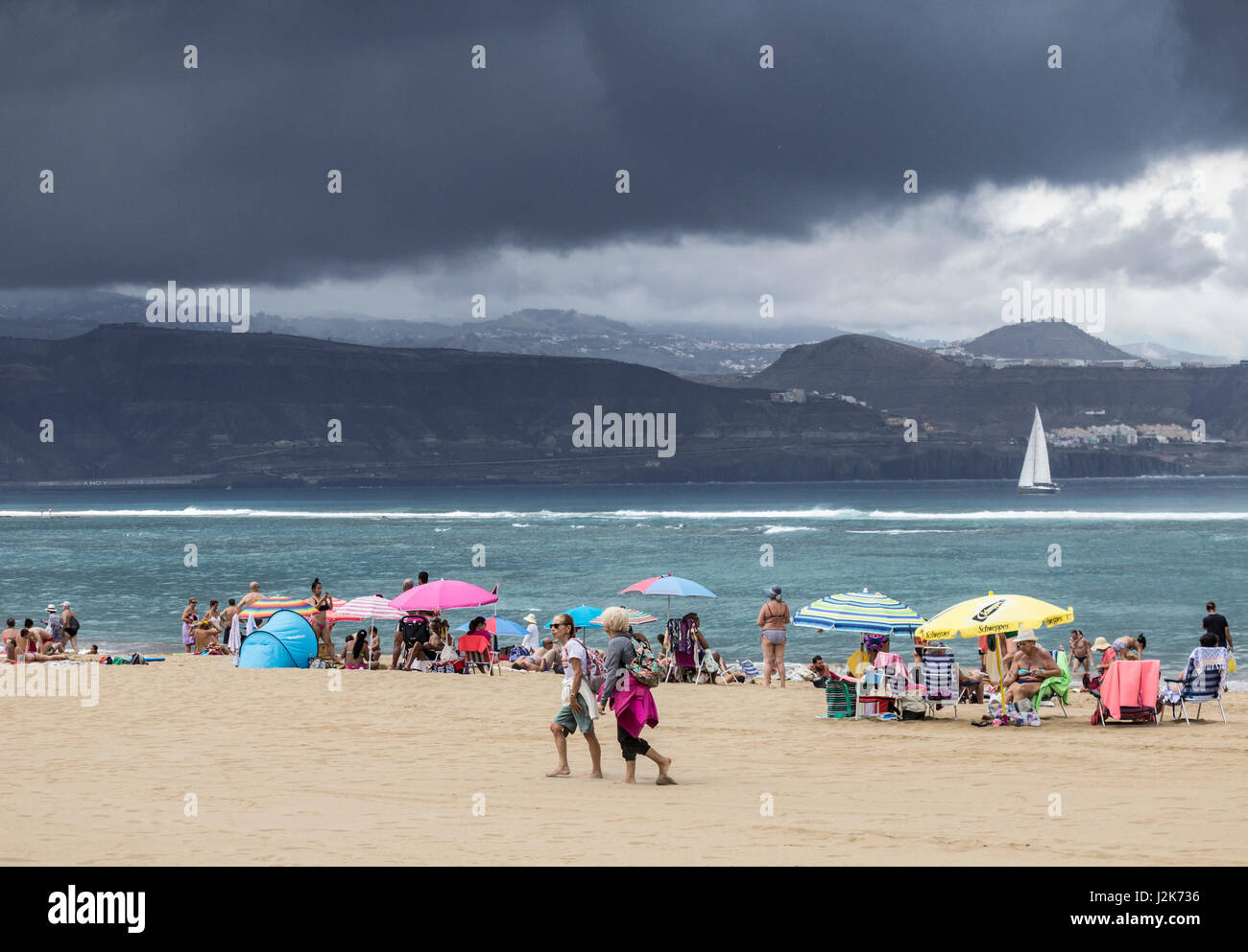 A Las Palmas di Gran Canaria Isole Canarie Spagna 29 Aprile, 2017. Meteo: nuvole temporalesche brew oltre le montagne di Gran Canaria, cinque minuti dopo una pioggia torrenziale è caduta sulla spiaggia della città di Las Palmas con le persone che eseguono per coprire. Credito: ALAN DAWSON/Alamy Live News Foto Stock