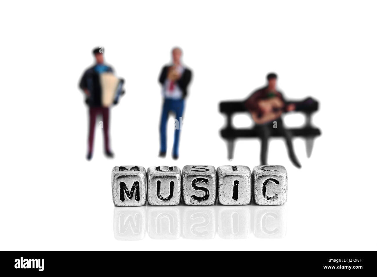 Miniatura modello in scala i musicisti in piedi dietro la parola musica su perline Foto Stock