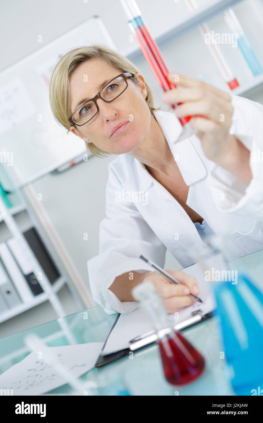 Primo piano della bella lab lavoratore mantenendo la provetta Foto Stock