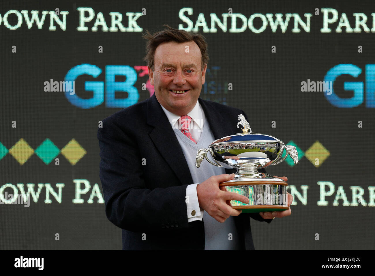 Trainer Nicky Henderson con il campione nazionale di formatori di suoneria Trofeo a lui presentati durante il Bet365 Gold Cup giorno a Sandown Racecourse. Foto Stock