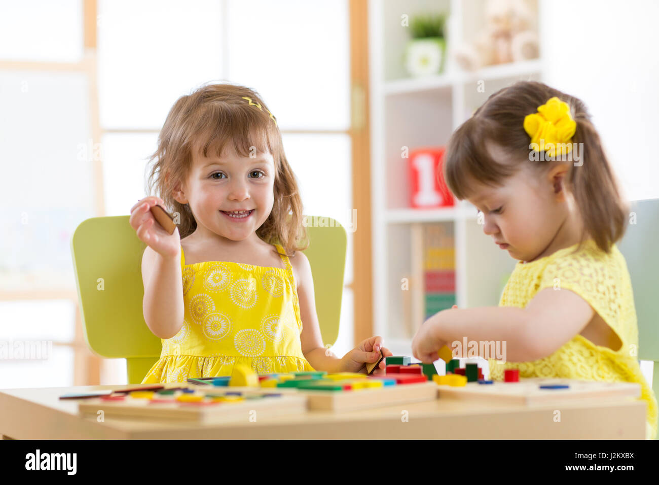 Ragazzi che giocano a bloccare i giocattoli in sala giochi al vivaio Foto Stock