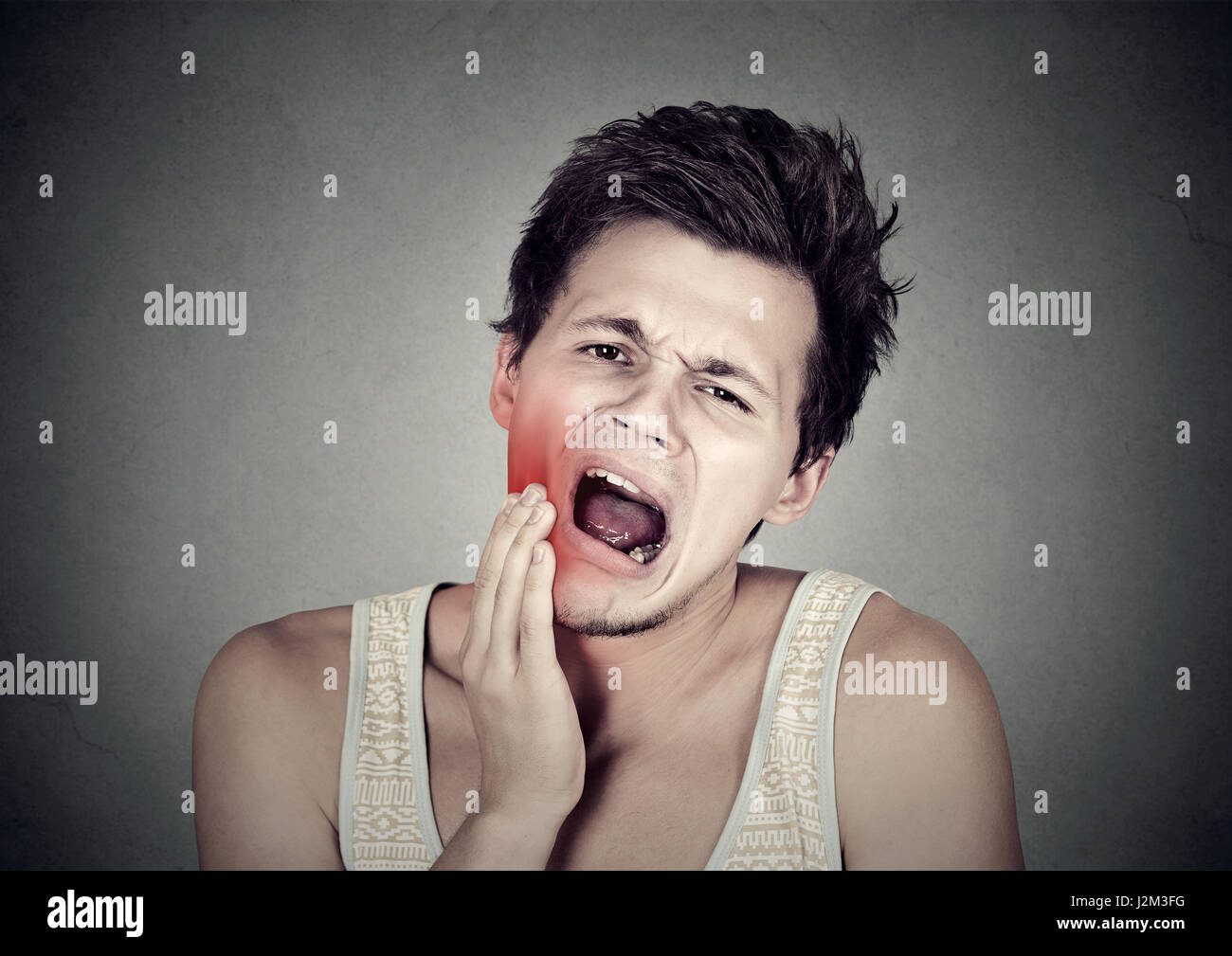 Giovane con un mal di denti Dente dolore al di fuori della bocca guancia colorati in rosso Foto Stock