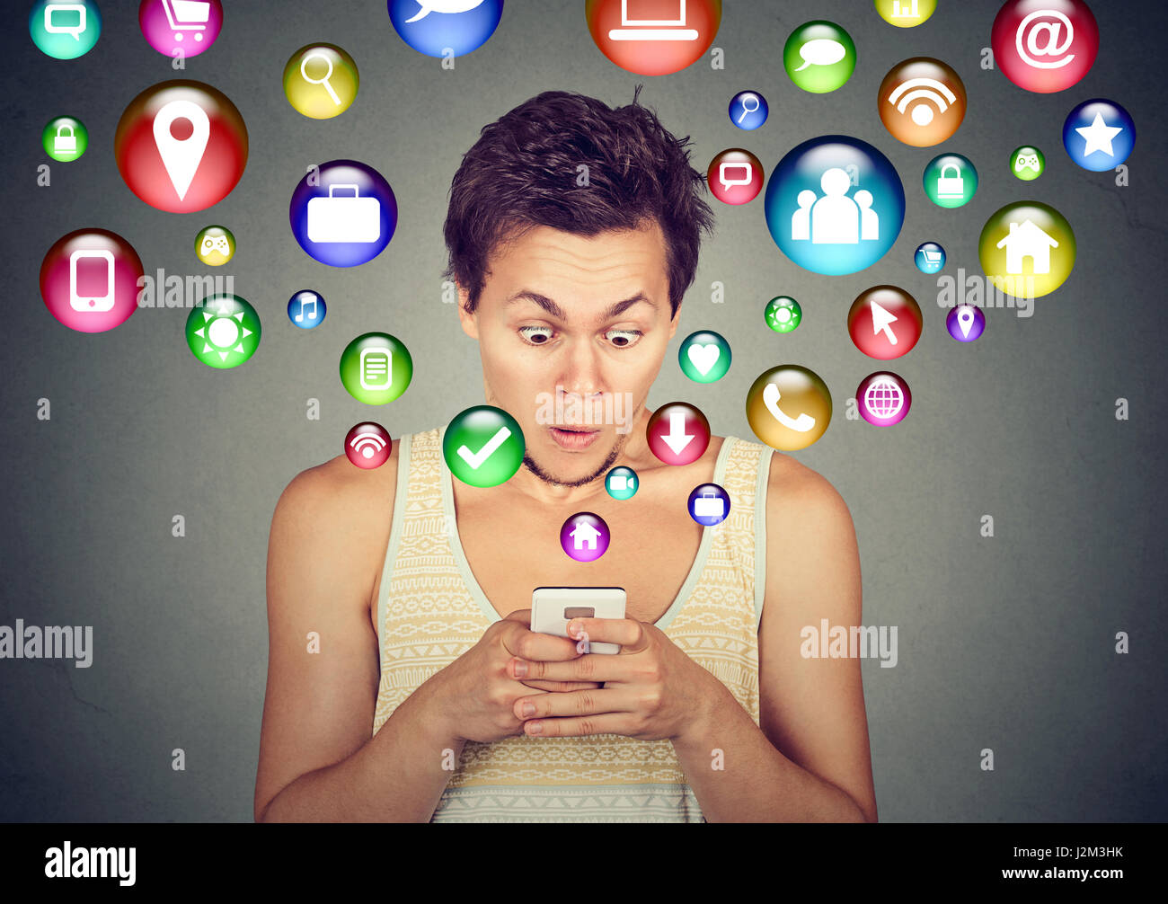 La tecnologia di comunicazione mobile phone high tech concetto. Scioccato uomo bello utilizzando messaggi di testo sullo smartphone le icone delle applicazioni battenti fuori del cellulare sc Foto Stock