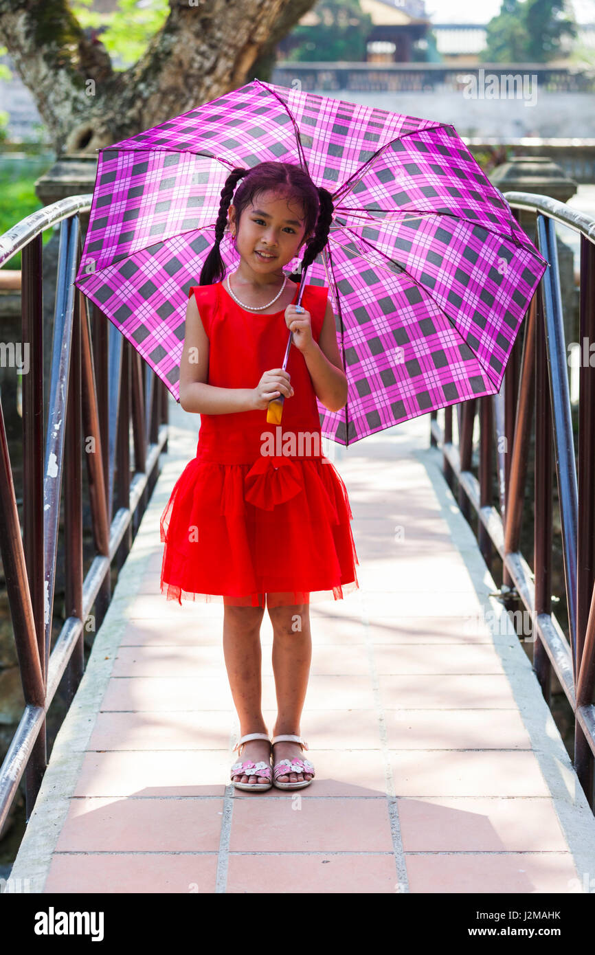 Il Vietnam, tonalità di tinta Città Imperiale, i ruderi della viola la Città Proibita, ragazza giovane con ombrellone Foto Stock