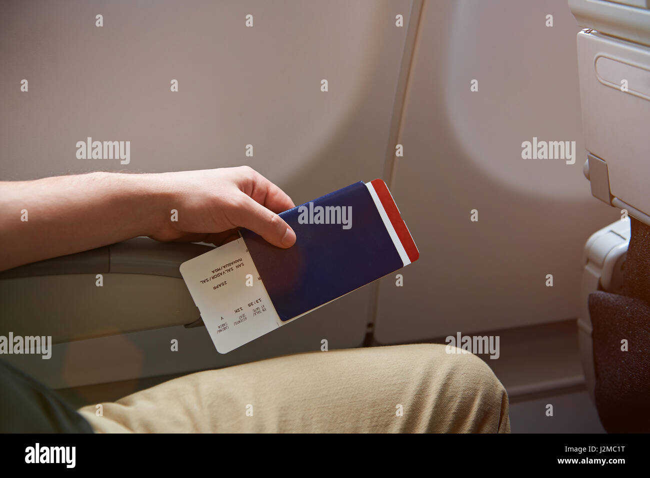 Uomo con passaporto in mano seduto in aereo close-up Foto Stock