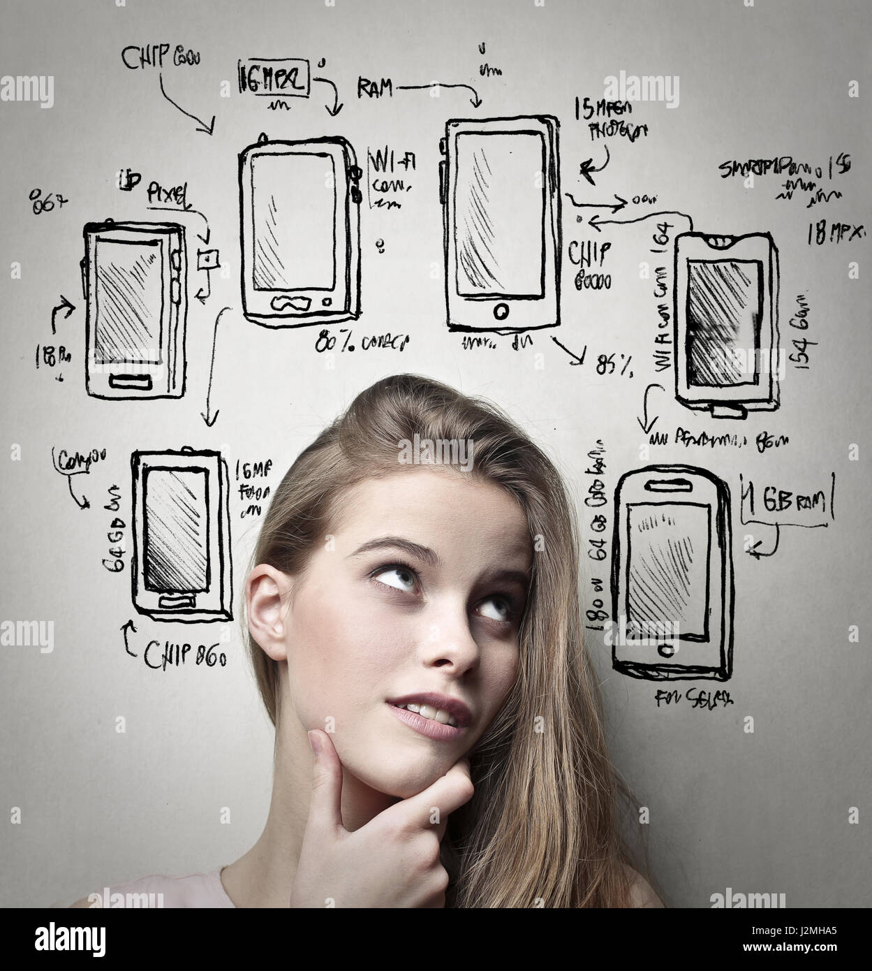 Donna pensare circa il suo nuovo telefono Foto Stock