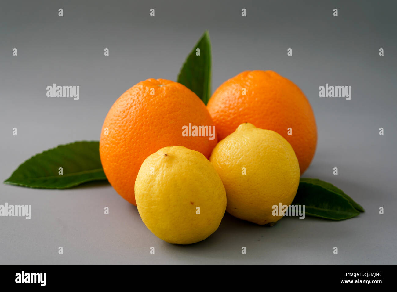 Organici di arancia e di limone su sfondo grigio - isolato Foto Stock