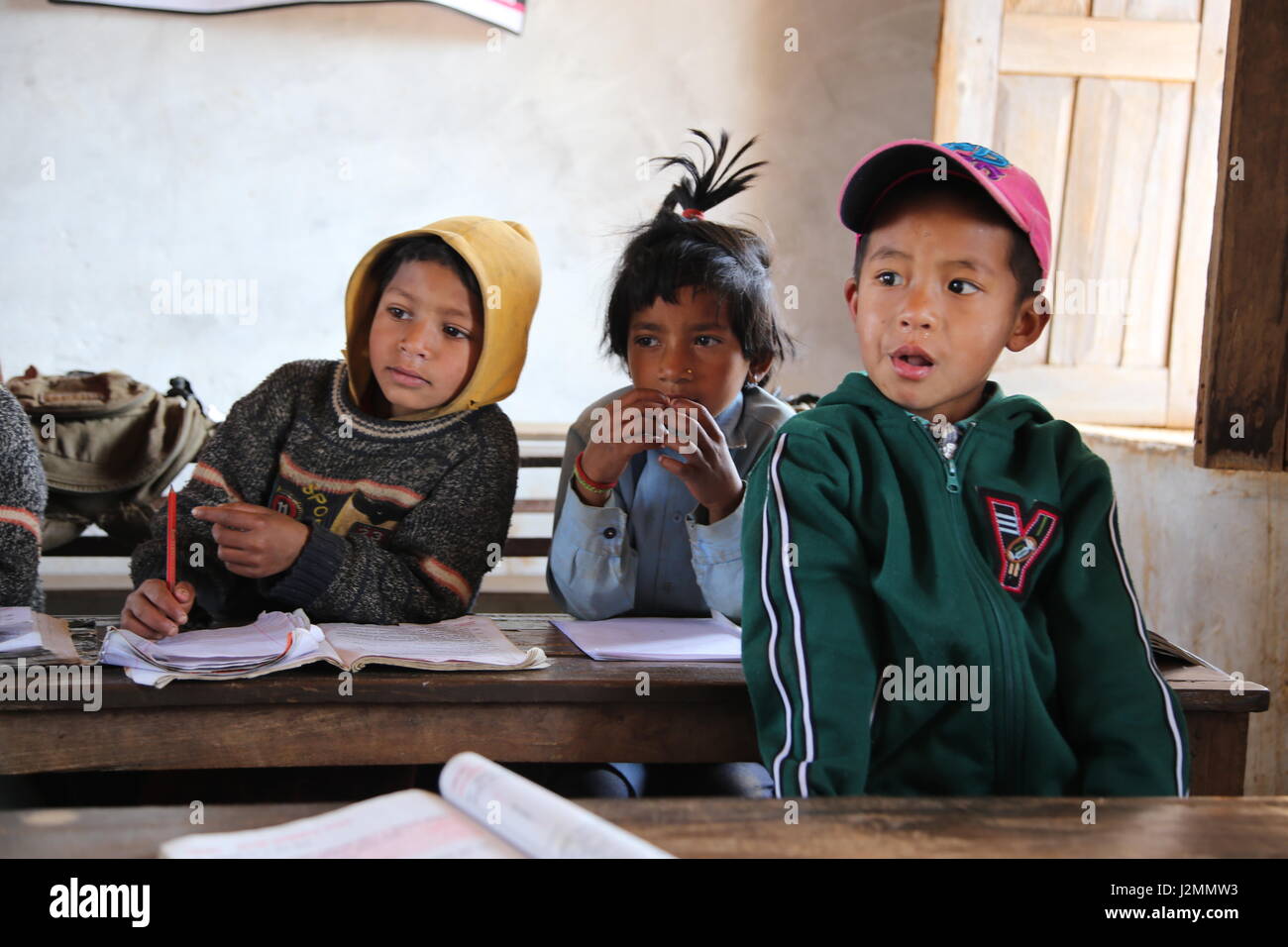 A scuola i bambini ed i bambini in campagna locale scuola in Nepal centrale vicino Bandjpur giocando e ricevere istruzione da Foto Stock