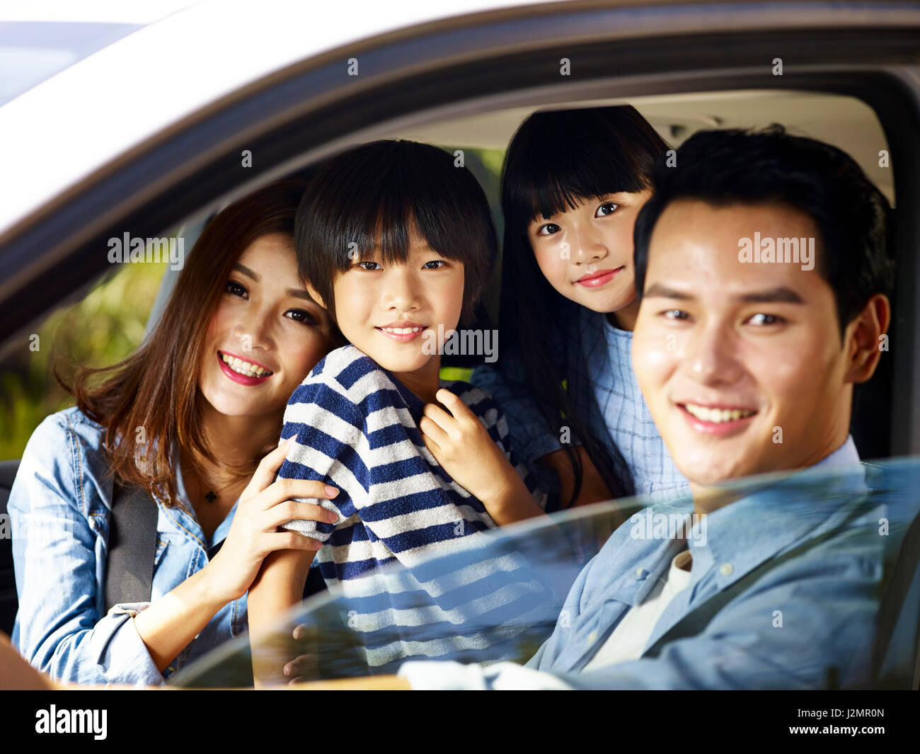 Felice famiglia asiatica con due bambini che viaggiano in auto, concentrarsi su il ragazzino. Foto Stock