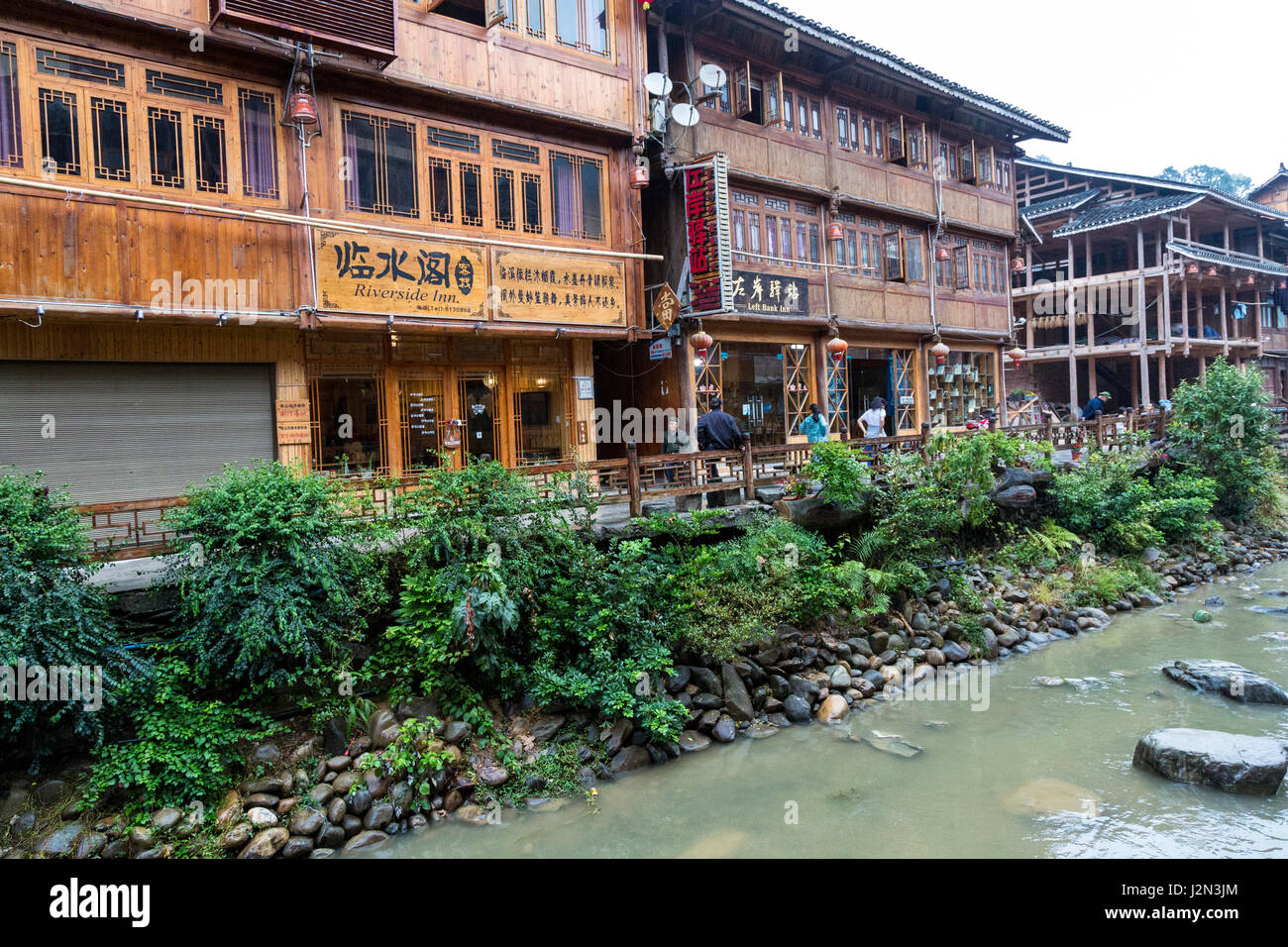 Zhaoxing, Guizhou, Cina, a Dong villaggio di minoranza. Due gli hotel boutique e negozi dal bordo del fiume. Foto Stock