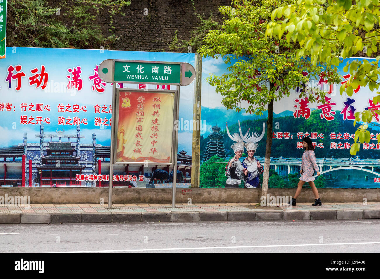 Kaili, Guizhou, Cina. Scena di strada. Cartellone di promozione regionale delle minoranze etniche. Foto Stock