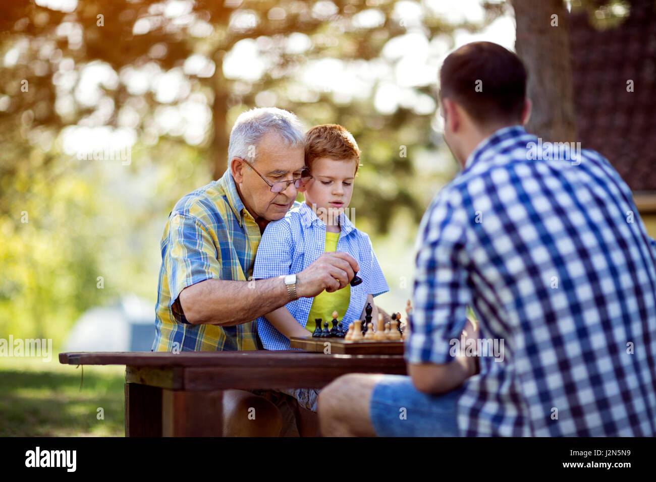 Nonno insegnamento sua nipote a scacchi in natura Foto Stock